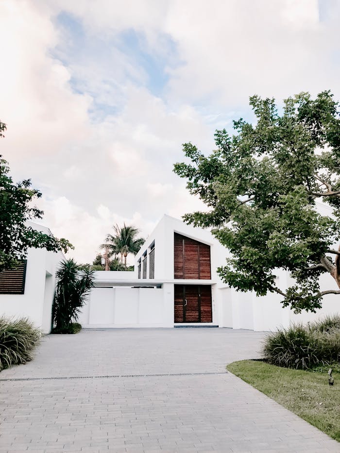 portfolio-05 Contemporary minimalist home exterior with lush landscaping and open driveway.