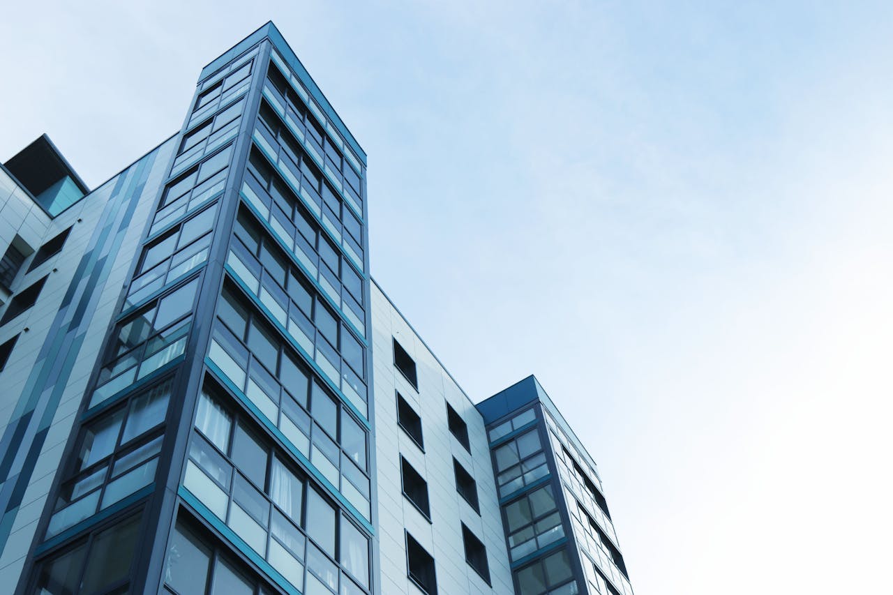 stats-img Low-angle view of a modern glass skyscraper against a clear sky in Poole, UK.